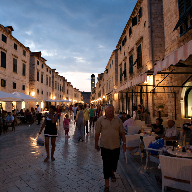 Vibrant nightlife under LED street lights with people enjoying city restaurants