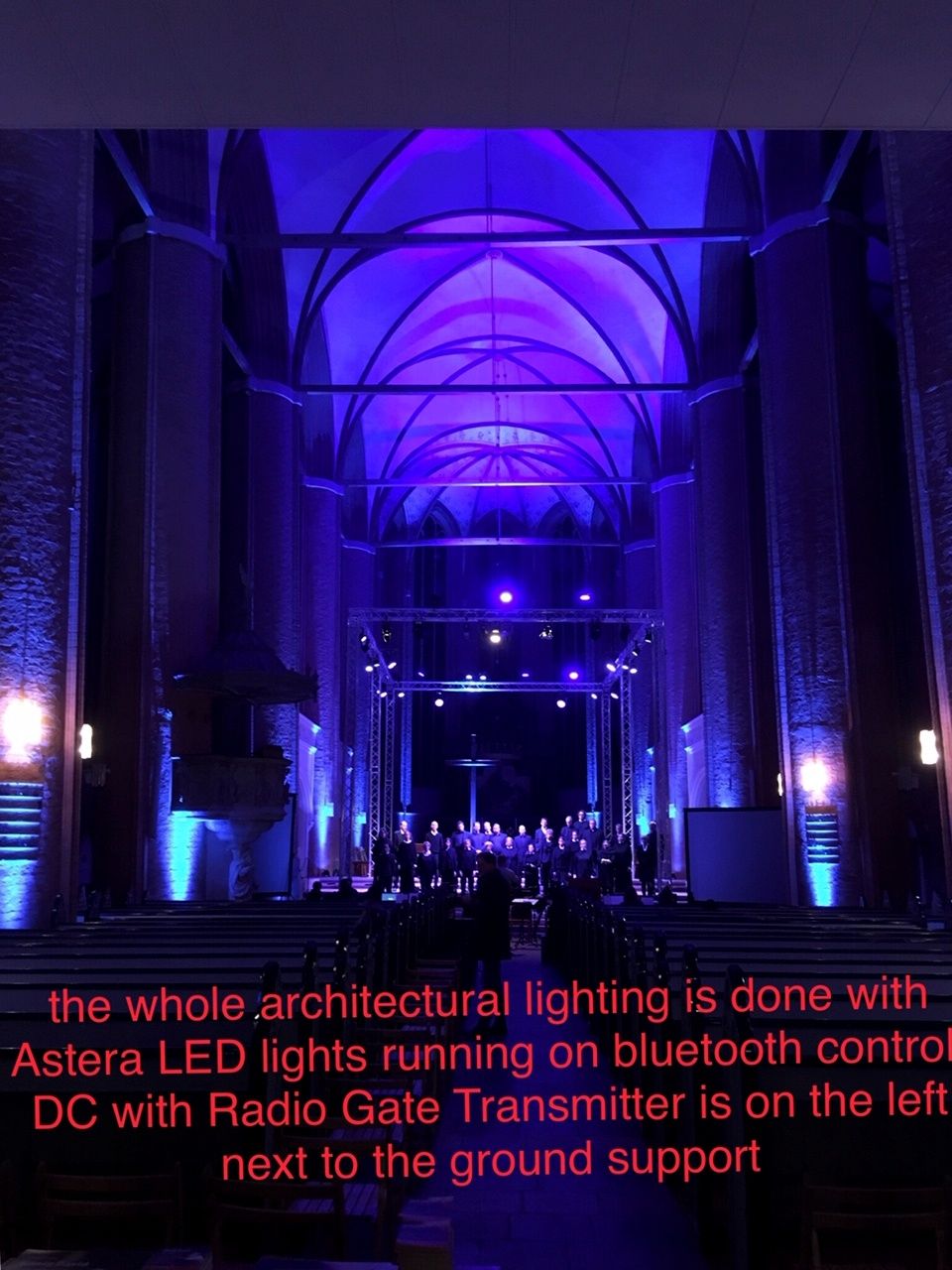 Photo showcasing Astera LED lights illuminating St. Michael's Church with Bluetooth control, powered by a RadioGate Transmitter near the ground support in Lüneburg's historic Gothic venue.