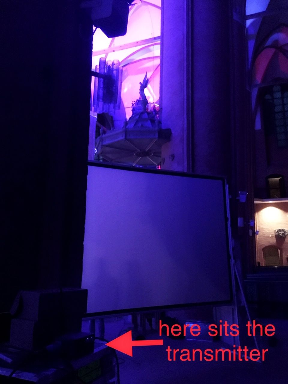 Image showing the RadioGate Solid transmitter positioned near Astera LED equipment behind a stone column in Lüneburg's historic St. Michael's Church, enabling wireless DMX control for lighting.