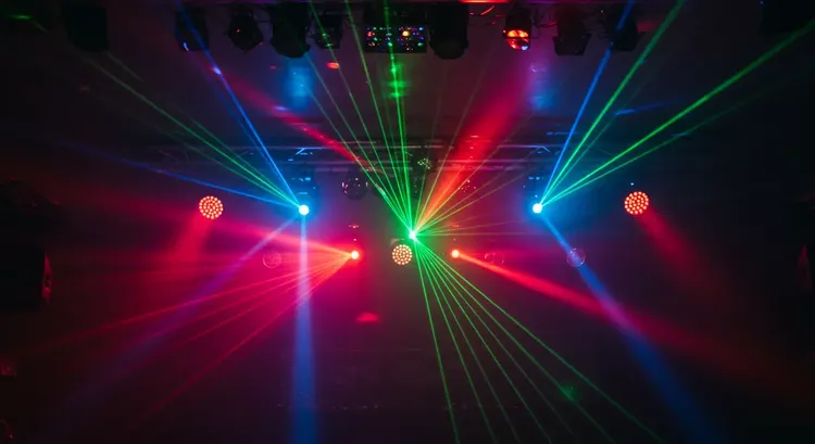 A lighting technician sets up a Sundrax RadioGate transceiver to transmit DMX signals wirelessly across a rotating theater stage using the beDMX protocol.